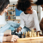 Happy family playing chess together at home